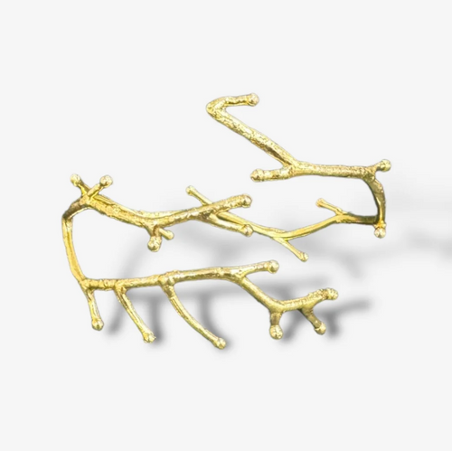 Gold branch-shaped bracelet on a light gray background