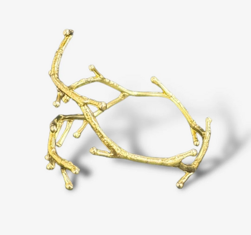 Gold branch-like bracelet piece on a white background