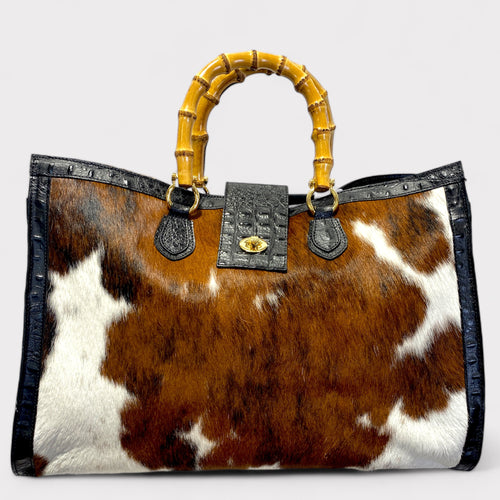 A tote bag with crocodile-like pattern on the leather, featuring bamboo handles and a detachable shoulder strap.